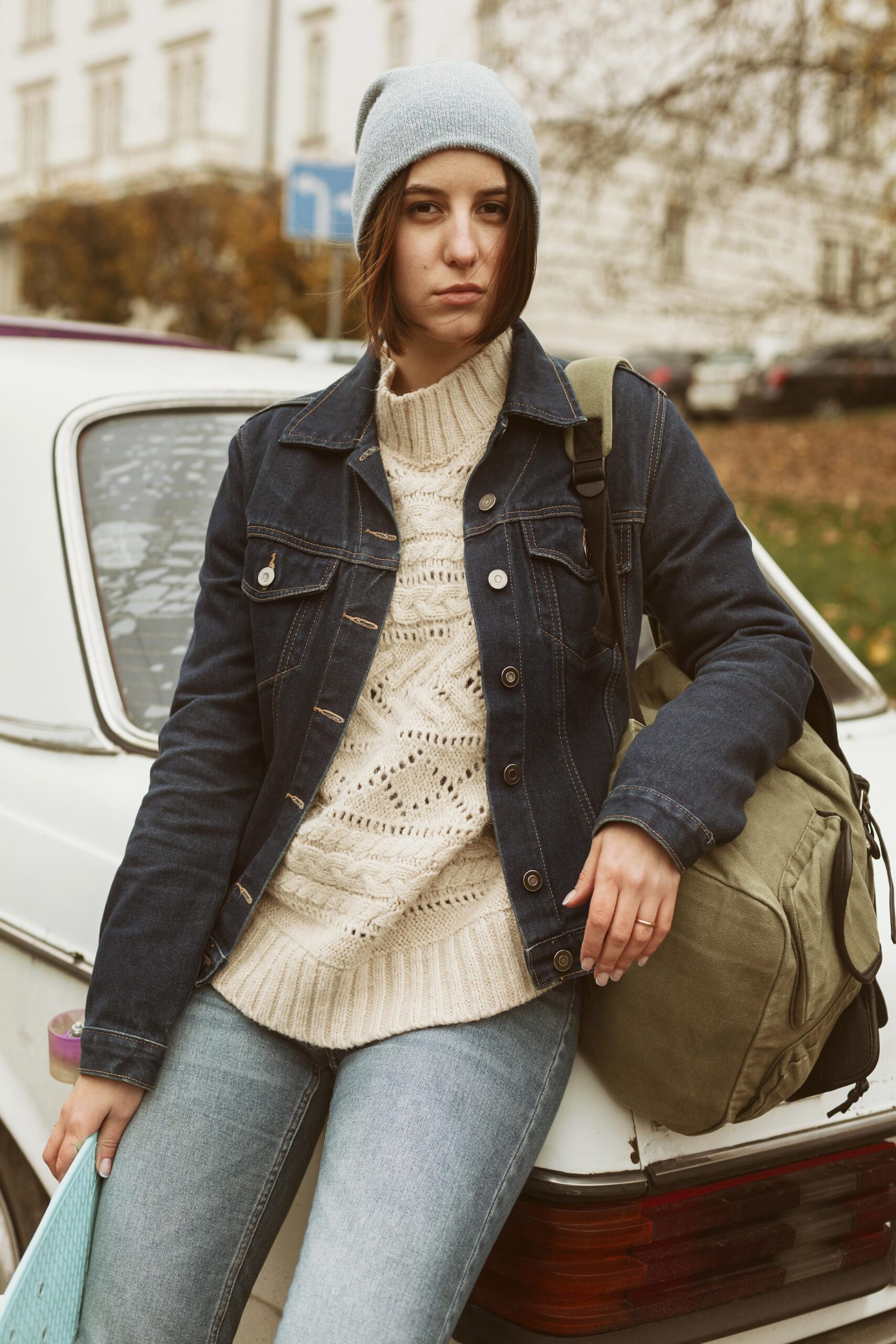 woman-holding-her-skateboard-while-sitting-car